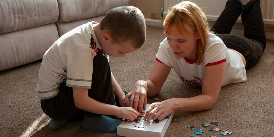 Parent and child enjoying a brain game together at home, fostering learning and connection
